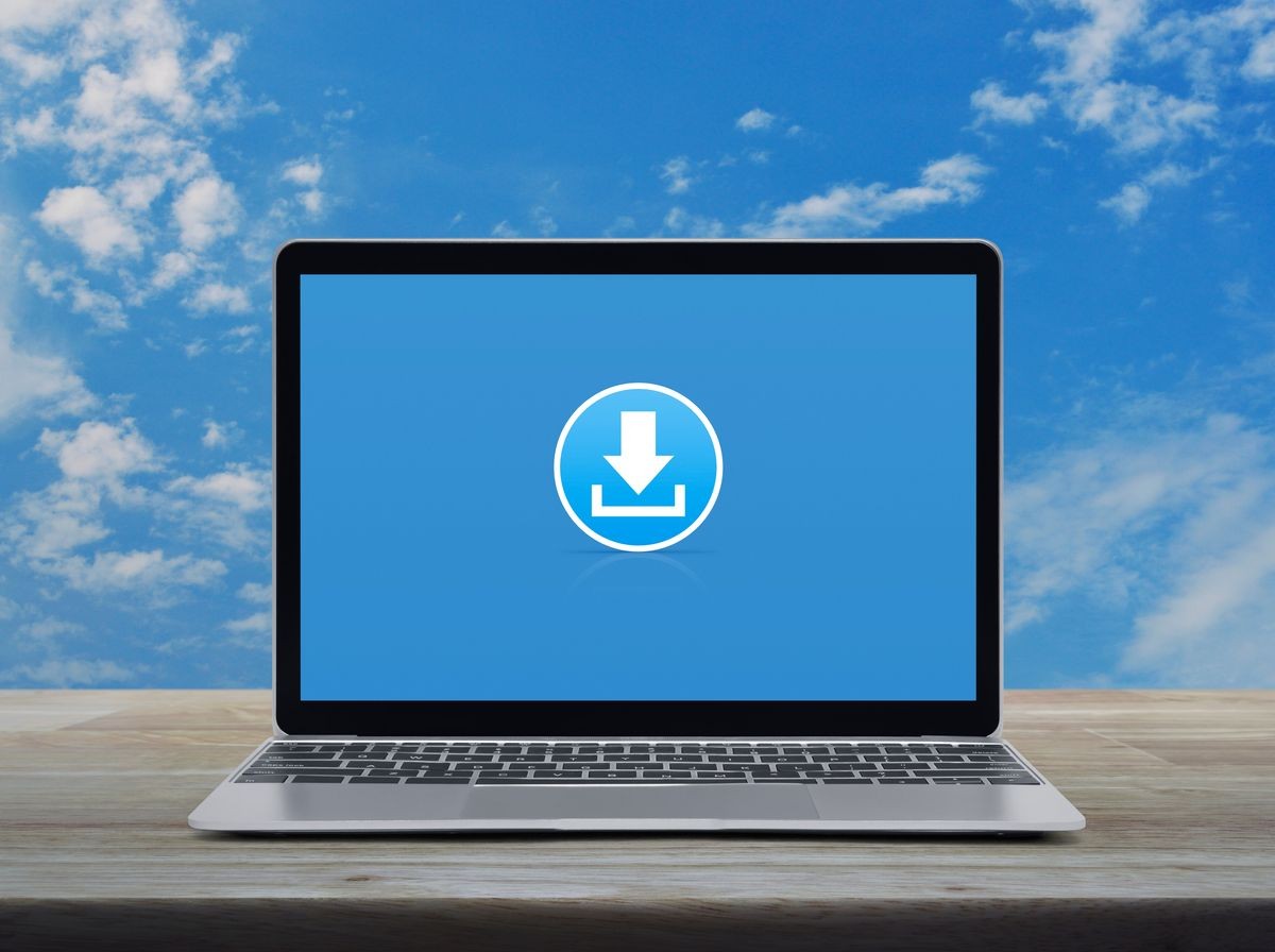 Download flat icon with modern laptop computer on wooden table over blue sky with white clouds, Business internet online concept